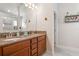 Bathroom featuring granite countertop with double vanity sinks and a large mirror at 6555 Sparkling Way, Wesley Chapel, FL 33545