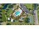 A nice aerial view of a clean community pool, nearby playground, basketball court, and parking at 6555 Sparkling Way, Wesley Chapel, FL 33545
