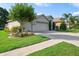 Charming home with well-maintained landscaping, mature trees, and a three-car garage at 6555 Sparkling Way, Wesley Chapel, FL 33545
