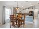 Open-concept dining area with pendant lighting, connecting to modern kitchen with island seating at 6555 Sparkling Way, Wesley Chapel, FL 33545
