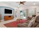 Comfortable living room with a ceiling fan, television, and sliding glass doors at 6555 Sparkling Way, Wesley Chapel, FL 33545