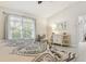 Bright main bedroom features a ceiling fan, a large window, and a full-size bed at 6555 Sparkling Way, Wesley Chapel, FL 33545