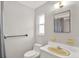 Well-lit bathroom featuring a yellow sink, large mirror, and white walls at 7092 119Th St, Seminole, FL 33772
