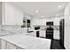 Modern kitchen featuring white cabinets, marble backsplash, sleek countertops, and stainless steel appliances at 7092 119Th St, Seminole, FL 33772