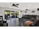 Open living room with dark floors, ceiling fans, and large sliding doors to a screened outdoor patio at 7092 119Th St, Seminole, FL 33772