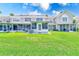 Lush green backyard featuring a screened-in porch, offering a tranquil outdoor living space at 727 Kensington Lake Cir, Brandon, FL 33511