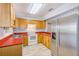 Well lit kitchen with a stainless steel refrigerator, light wood cabinets, and white appliances at 727 Kensington Lake Cir, Brandon, FL 33511