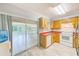 This is a well-lit kitchen with white appliances, wood cabinetry, and an easy access sliding glass door at 727 Kensington Lake Cir, Brandon, FL 33511