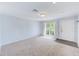 Bright living room featuring neutral walls, carpet flooring, and a large window offering natural light at 727 Kensington Lake Cir, Brandon, FL 33511