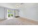 Bright living room featuring neutral walls, carpet flooring, and a large window offering natural light at 727 Kensington Lake Cir, Brandon, FL 33511