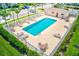 Aerial view of a fenced community pool with several lounge chairs and tables at 727 Kensington Lake Cir, Brandon, FL 33511