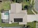 Aerial view of a property highlighting the roof, solar panels, screened-in pool, and surrounding landscaping at 7600 Drew Oak Dr, Seminole, FL 33772