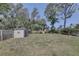 Large backyard with deck, shed, and privacy fence surrounded by mature trees for quiet enjoyment at 7600 Drew Oak Dr, Seminole, FL 33772