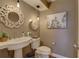 Stylish half bathroom featuring modern fixtures, palm tree art, and elegant decorative mirror at 7600 Drew Oak Dr, Seminole, FL 33772