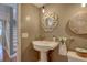 Stylish half bathroom featuring modern fixtures, decorative mirror and a classic pedestal sink at 7600 Drew Oak Dr, Seminole, FL 33772