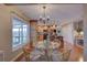 Dining area with glass table, wicker chairs, chandelier, and seamless flow to the kitchen at 7600 Drew Oak Dr, Seminole, FL 33772