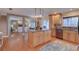 Open kitchen featuring an island, wooden cabinets, granite countertops, stainless steel appliances, and hardwood floors at 7600 Drew Oak Dr, Seminole, FL 33772