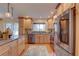 Spacious kitchen boasting stainless appliances, wooden cabinetry, granite countertops, and hardwood floors at 7600 Drew Oak Dr, Seminole, FL 33772