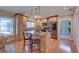 Bright kitchen featuring an island with seating, wooden cabinetry, granite countertops, stainless appliances, and hardwood floors at 7600 Drew Oak Dr, Seminole, FL 33772