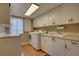 Efficient laundry room features ample cabinet space, modern washer and dryer, and convenient sink at 7600 Drew Oak Dr, Seminole, FL 33772
