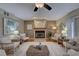 Cozy living room with a fireplace, ceiling fan, hardwood floors, and neutral decor with lots of seating options at 7600 Drew Oak Dr, Seminole, FL 33772