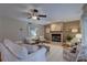 Bright living room boasts a fireplace, ceiling fan, hardwood floors, light decor and lots of seating options at 7600 Drew Oak Dr, Seminole, FL 33772
