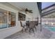 Enjoy outdoor dining with a screened-in pool view, ceiling fan, and wall-mounted television at 7600 Drew Oak Dr, Seminole, FL 33772