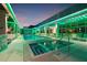 A luxurious rooftop pool and hot tub are illuminated by stylish green neon lighting at night at 777 3Rd N Ave # 905, St Petersburg, FL 33701