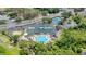 Aerial view of the clubhouse, pool, tennis courts, and surrounding green spaces at 9735 Conservation Dr, New Port Richey, FL 34655