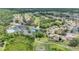 Aerial view showing community pool and tennis courts near homes and lush surroundings at 9735 Conservation Dr, New Port Richey, FL 34655
