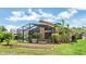 Well-maintained backyard featuring a screened-in lanai and lush landscaping at 9735 Conservation Dr, New Port Richey, FL 34655
