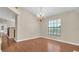 Elegant dining room featuring hardwood floors, a chandelier, and natural light from the window at 9735 Conservation Dr, New Port Richey, FL 34655