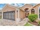 Charming single-story home featuring a brick driveway, well-manicured lawn, and an attached two-car garage at 9735 Conservation Dr, New Port Richey, FL 34655