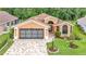 Inviting home with a paver driveway, two-car garage, and manicured lawn at 9735 Conservation Dr, New Port Richey, FL 34655