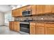Traditional kitchen features stainless steel appliances and light wood cabinets at 9735 Conservation Dr, New Port Richey, FL 34655