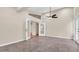Open-concept living room with tile flooring, doors to different areas, and ceiling fan at 9735 Conservation Dr, New Port Richey, FL 34655