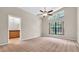 Spacious main bedroom with a large window and view into the ensuite bathroom at 9735 Conservation Dr, New Port Richey, FL 34655