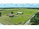 Aerial view of ranch showing the home, surrounding fenced pasture and nearby wooded areas at 9780 Allen Rd, Lithia, FL 33547