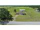 Aerial view of the ranch, showing the house, barn, adjacent fields and mature trees at 9780 Allen Rd, Lithia, FL 33547