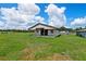 A light-colored barn with a covered area stands amid a grassy field under a bright sky, perfect for rural living at 9780 Allen Rd, Lithia, FL 33547