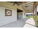 Open-air barn featuring concrete floors, multiple ceiling fans, and access to adjacent stalls at 9780 Allen Rd, Lithia, FL 33547