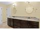 Bathroom featuring a double vanity with dark wood cabinets, granite countertops, and oval mirrors at 9780 Allen Rd, Lithia, FL 33547
