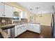 Open kitchen with granite countertops, white cabinets, stainless dishwasher, and eat-in counter at 9780 Allen Rd, Lithia, FL 33547