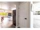 Hallway with wood flooring leading into living area and modern kitchen with white cabinets at 3254 Great Neck St, Port Charlotte, FL 33952