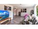 Spacious living room featuring a large TV, comfortable gray sofa, wood-look floors, and modern decor at 3254 Great Neck St, Port Charlotte, FL 33952