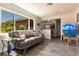 Inviting living room with wood floors, modern gray sofa, large windows, and TV at 3254 Great Neck St, Port Charlotte, FL 33952