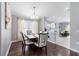 Charming dining area featuring hardwood floors, large window, and a stylish chandelier with views into the kitchen at 10811 Lakeside Vista Dr, Riverview, FL 33569
