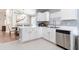 Modern kitchen featuring white cabinetry, stainless steel appliances and a convenient bar seating area at 10811 Lakeside Vista Dr, Riverview, FL 33569