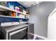 Well-lit laundry room with modern washer and dryer units and ample shelving space at 10811 Lakeside Vista Dr, Riverview, FL 33569