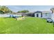 Large backyard with artificial turf, a utility shed, and play equipment for pets at 10954 96Th St, Largo, FL 33773